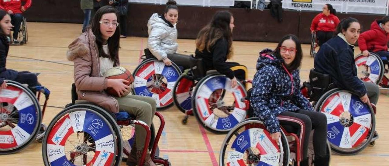 Un grupo de estudiantes del instituto prueban a jugar un partido de baloncesto en silla de ruedas.