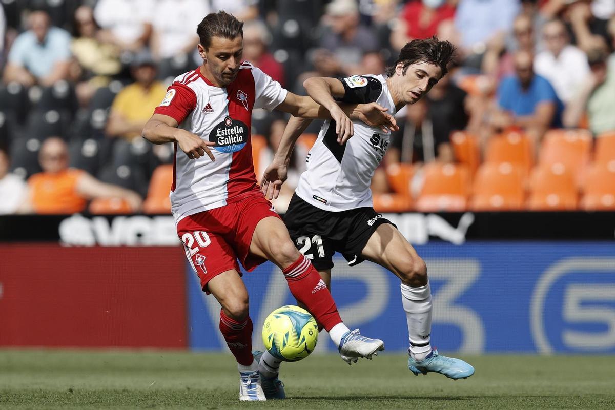 El defensa del Celta Kevin Vázquez (i) y el delantero del Valencia Bryan Gil Salvatierra luchan por el balón durante el partido de Liga que disputan en el estadio Mestalla de Valencia. EFE/ Kai Forsterling