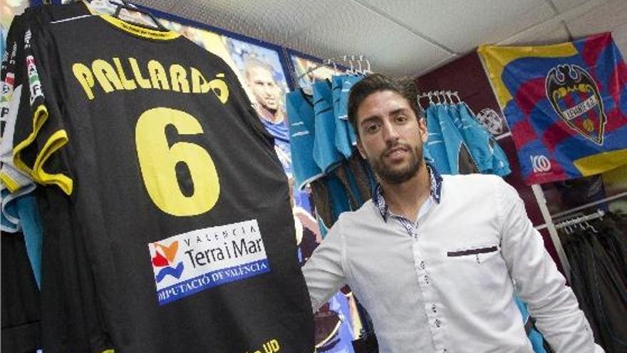 Miguel Pallardó posa ante una camiseta del Levante, ayer, tras ser anunciada su renovación.