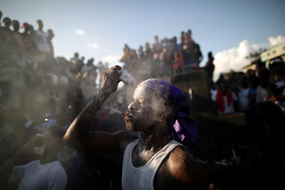 A Voodoo believer covers his face with baby ...