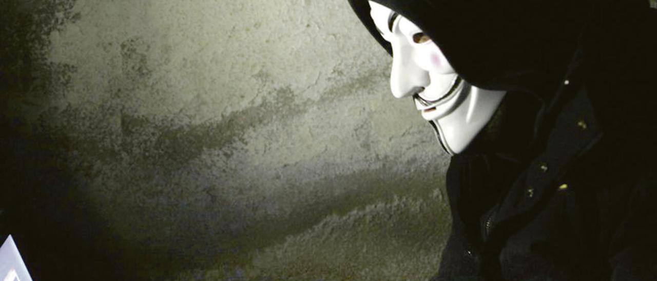 Una persona accede a un ordenador con una máscara de V de Vendetta.