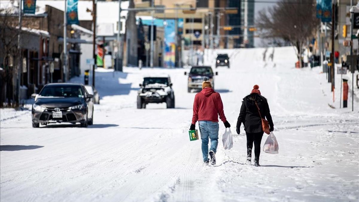 AUSTIN  TX - FEBRUARY 15  People carry groceries from a local gas station on February 15  2021 in Austin  Texas  Winter storm Uri has brought historic cold weather to Texas  causing traffic delays and power outages  and storms have swept across 26 states with a mix of freezing temperatures and precipitation    Montinique Monroe Getty Images AFP    FOR NEWSPAPERS  INTERNET  TELCOS   TELEVISION USE ONLY