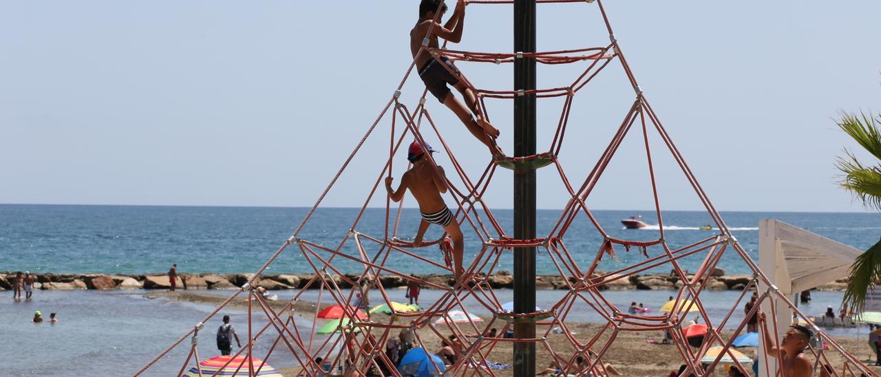 Dos niños juegan en una pirámide en la playa del Postiguet.