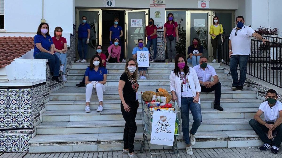 Las fundadoras de Aguja Solidaria y algunos voluntarios con un carro con alimentos.