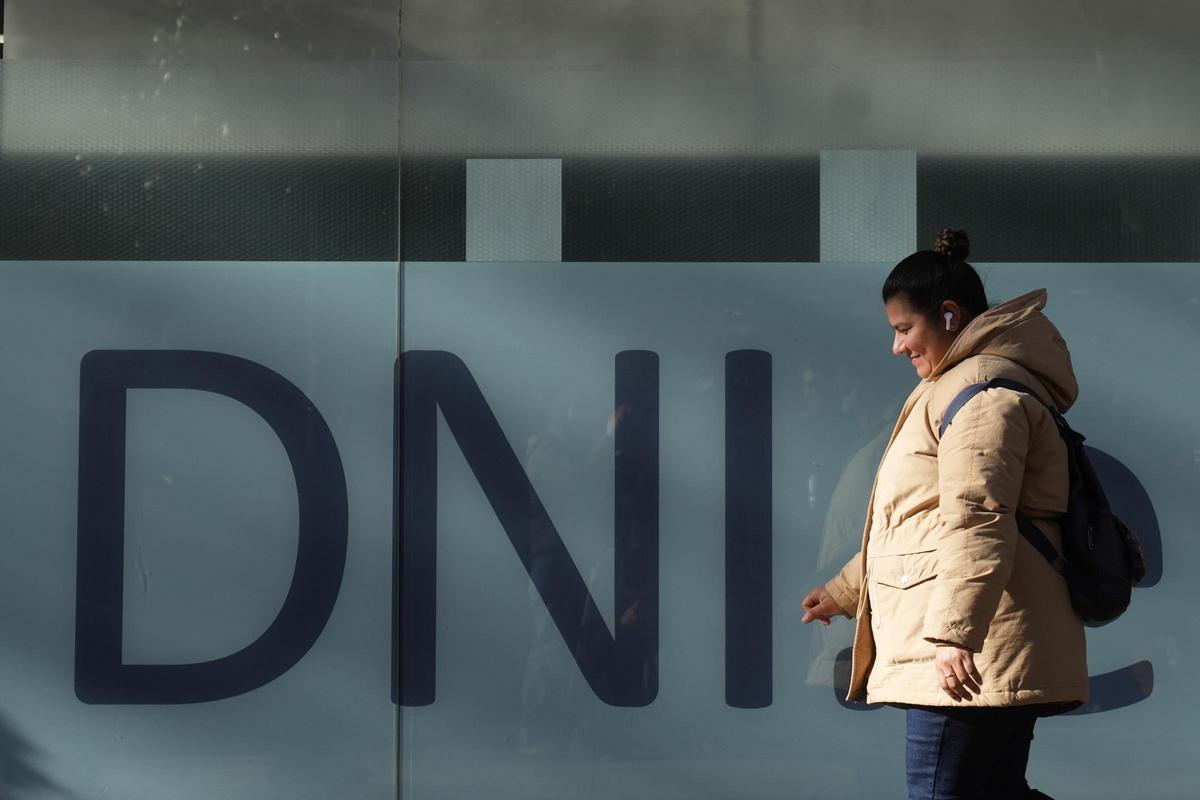Una dona davant d'una oficina d'estrangeria on es tramiten documents