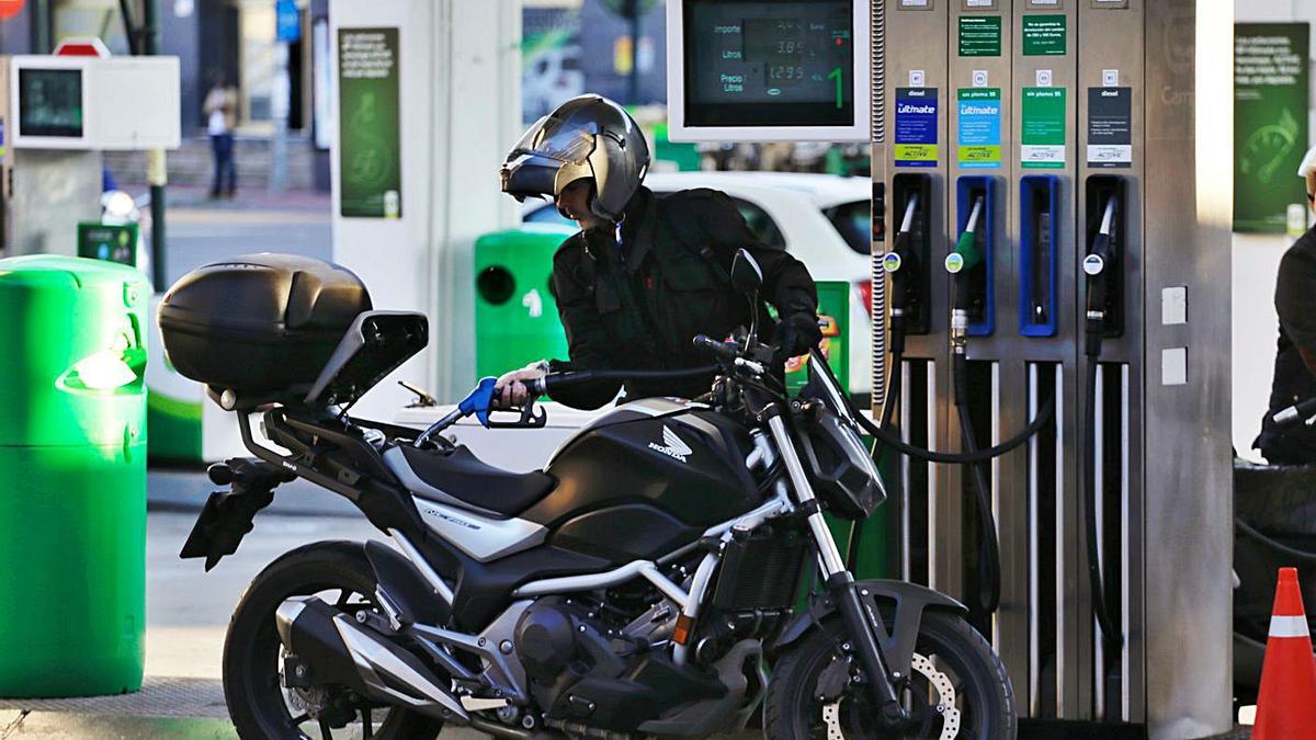 El conductor de una motocicleta reposta en una gasolinera. | JUAN CARLOS CAVAL