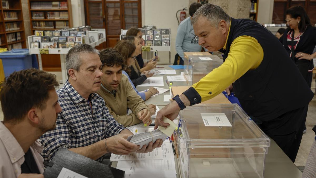 Un cartero entrega los votos emitidos por correo en una mesa electoral de Valencia.