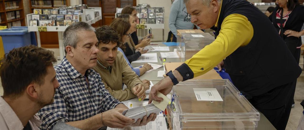 Un cartero entrega los votos emitidos por correo en una mesa electoral de Valencia.