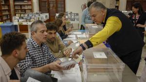 Un cartero entrega los votos emitidos por correo en una mesa electoral de Valencia.