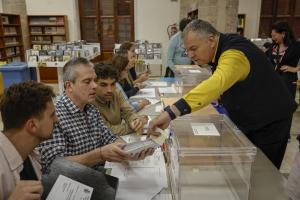 Un cartero entrega los votos emitidos por correo en una mesa electoral de Valencia.