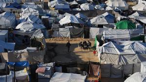 Displaced Palestinians gather outside a tent at a temporary camp in Deir al-Balah, central Gaza Strip, Saturday, Jan. 17, 2026. (AP Photo/Abdel Kareem Hana). EDITORIAL USE ONLY / ONLY ITALY AND SPAIN