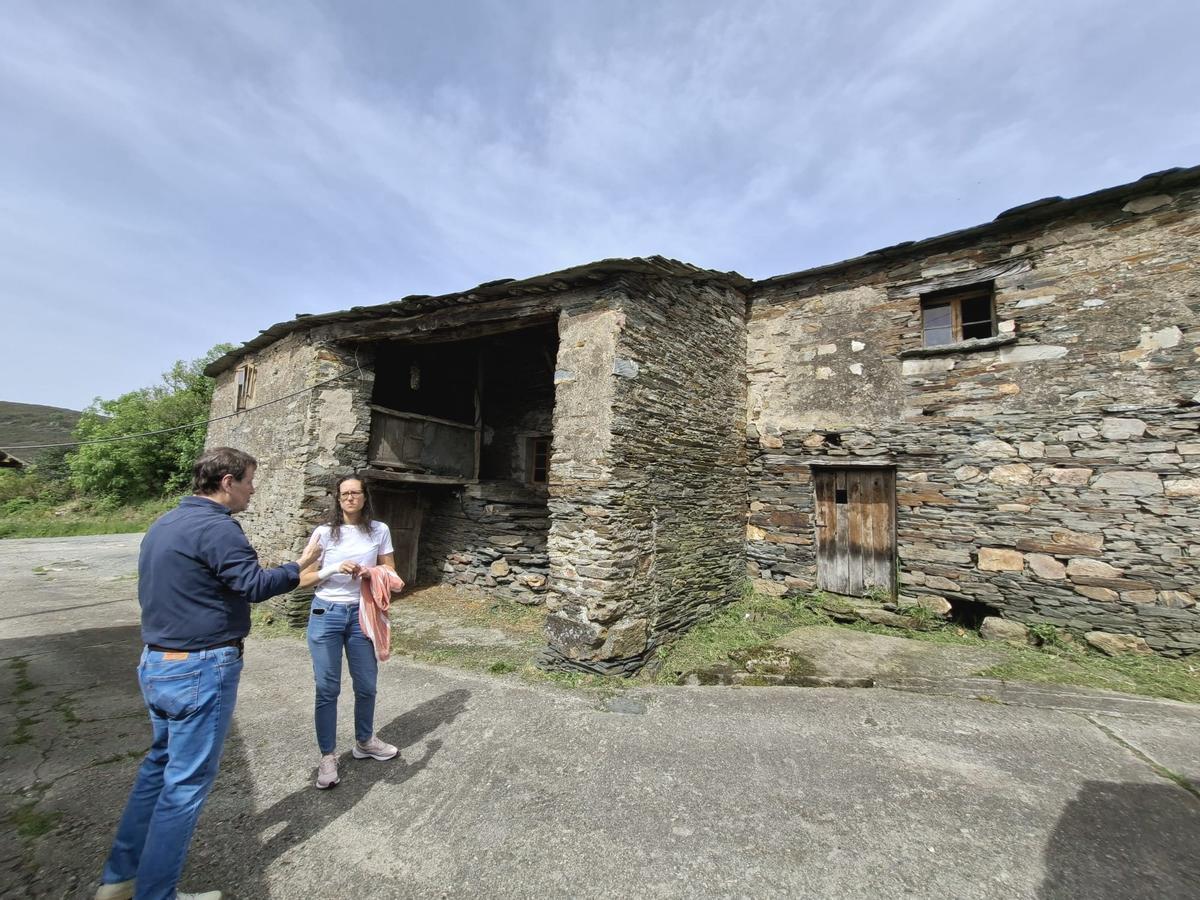 Enrique López y Ena Mateos junto a una casa deshabitada en Bustapena.