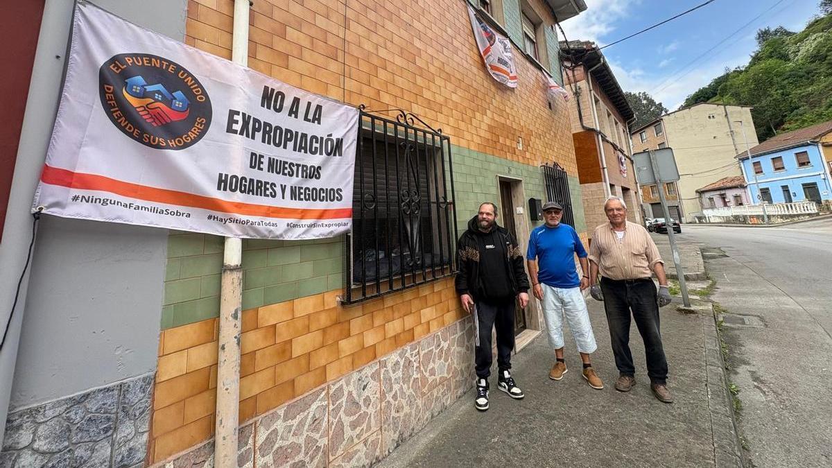 Por la izquierda, José Manuel Gómez, Juan Carlos Martínez y Amador Pérez ante la vivienda de este último en la calle José Álvarez Valdés del barrio de El Puente, en Langreo