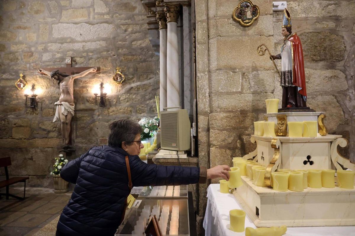 Una mujer ante la talla de San Blas en la capilla cambadesa.