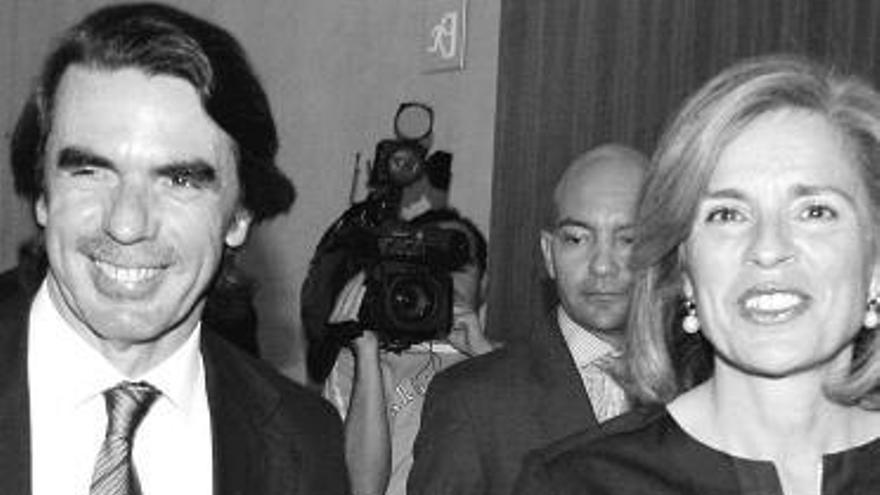 Aznar sonríe, con su esposa, ante los periodistas que lo esperaban en Madrid.