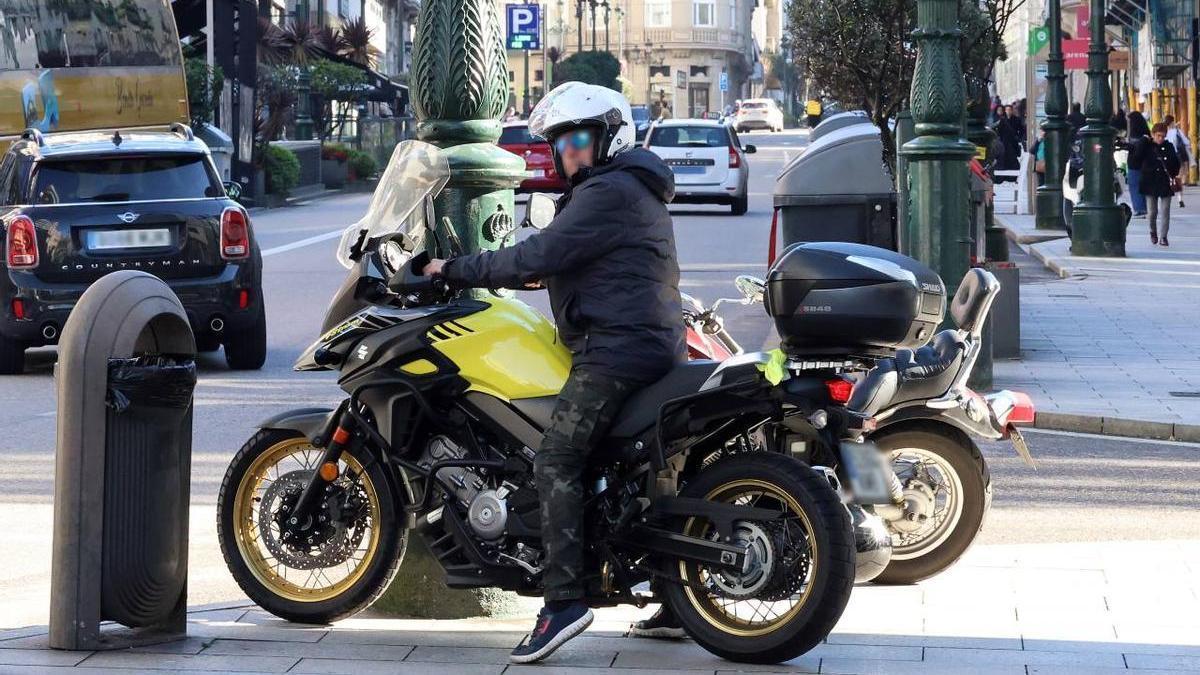 Foto de un motorista estacionado en un acera del centro de Vigo.