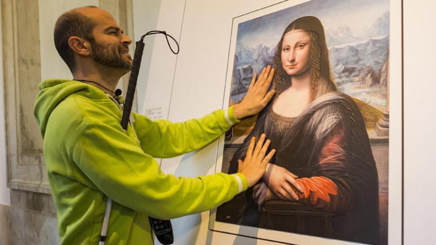 Un invident palpa &quot;La Gioconda&quot; de Leonardo da Vinci en l&#039;exposició.