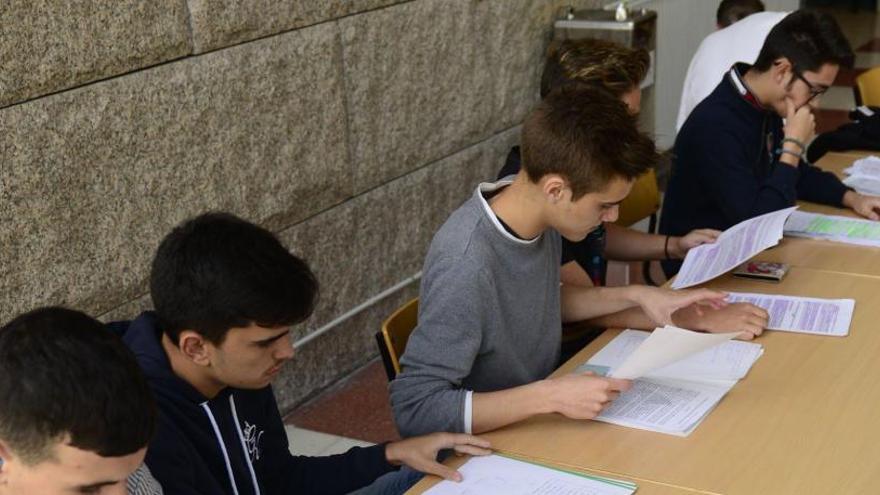 Estudiantes, con apuntes, en la Universidad.