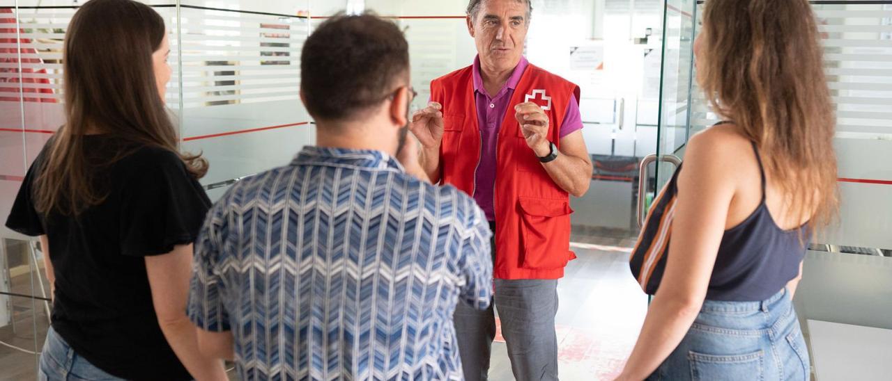 Alfredo Cabrero, voluntario de Cruz Roja Zamora, charla con tres usuarios del programa de acogida. | Emilio Fraile
