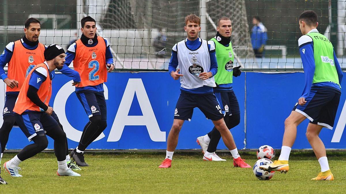 Yago Gandoy, en el centro, rodeado de compañeros en el entrenamiento de ayer en Abegondo. |  // CARLOS PARDELLAS