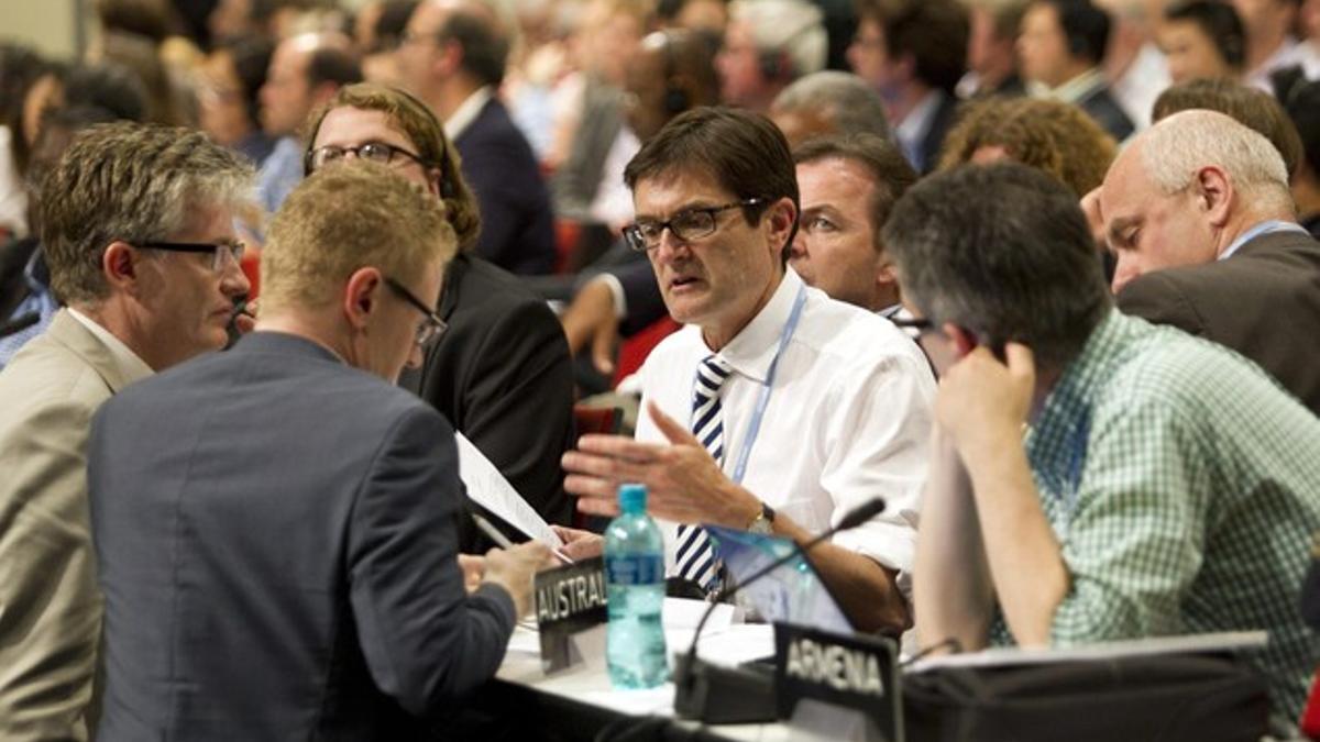 El ministro australiano de Medio Ambiente, Greg Combet (segundo por la derecha), habla con otros delegados en un descanso de la cumbre, el sábado, en Durban.