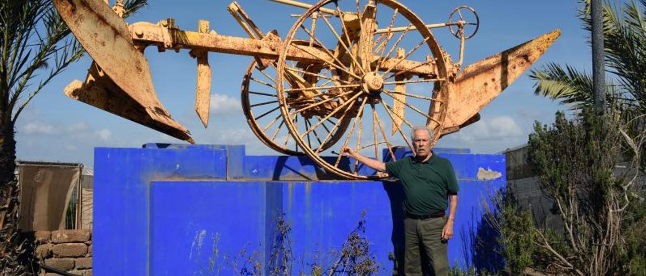 Felix Santiago Melián en su finca guiense de Matas Blancas, junto a una antigua máquina agrícola del inglés David J. Leacock en 2017