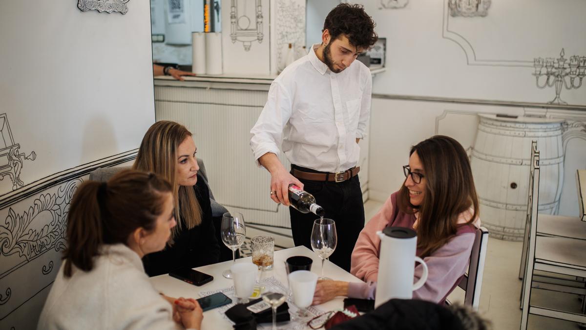 Un camarero sirve una copa de vino a varias mujeres en una imagen de archivo.