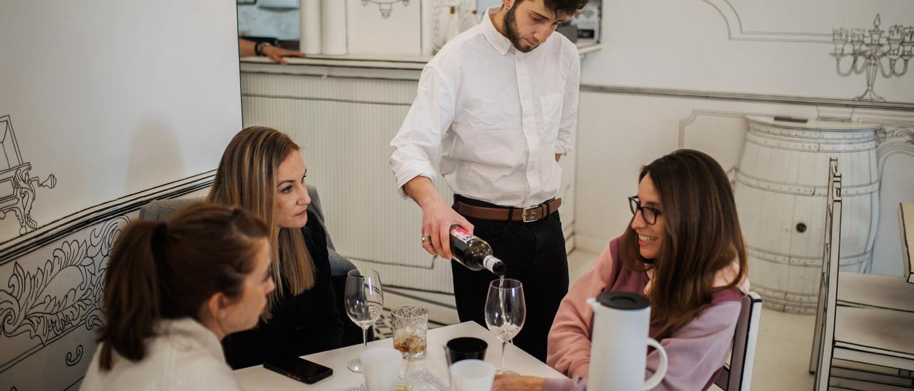 Un camarero sirve una copa de vino a varias mujeres en una imagen de archivo.