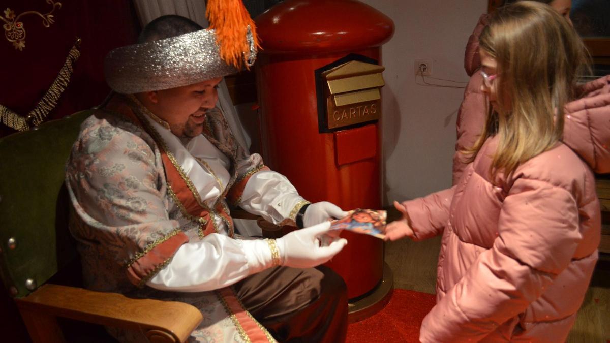 Una niña entregando la carta al paje real.