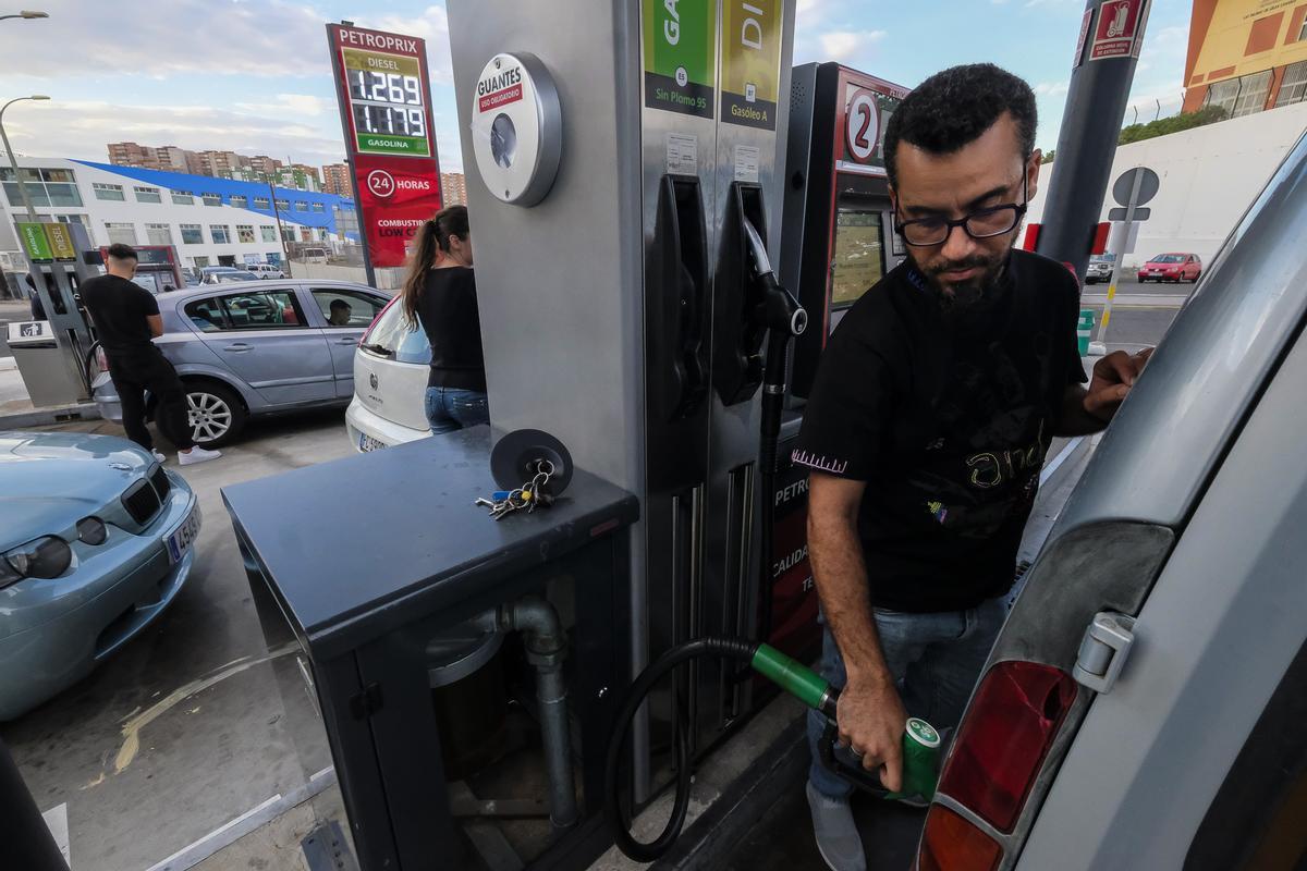 Un hombre pone gasolina en una estación de servicio.