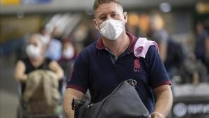 Un hombre con mascarilla para protegerse del coronavirus tras bajar de un avión en el aeropuerto de Sao Paulo, Brasil.