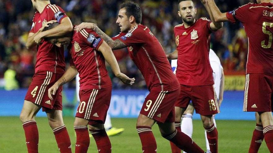 Bartra y Alcácer felicitan a Cazorla tras el primer gol de la selección española. // Efe