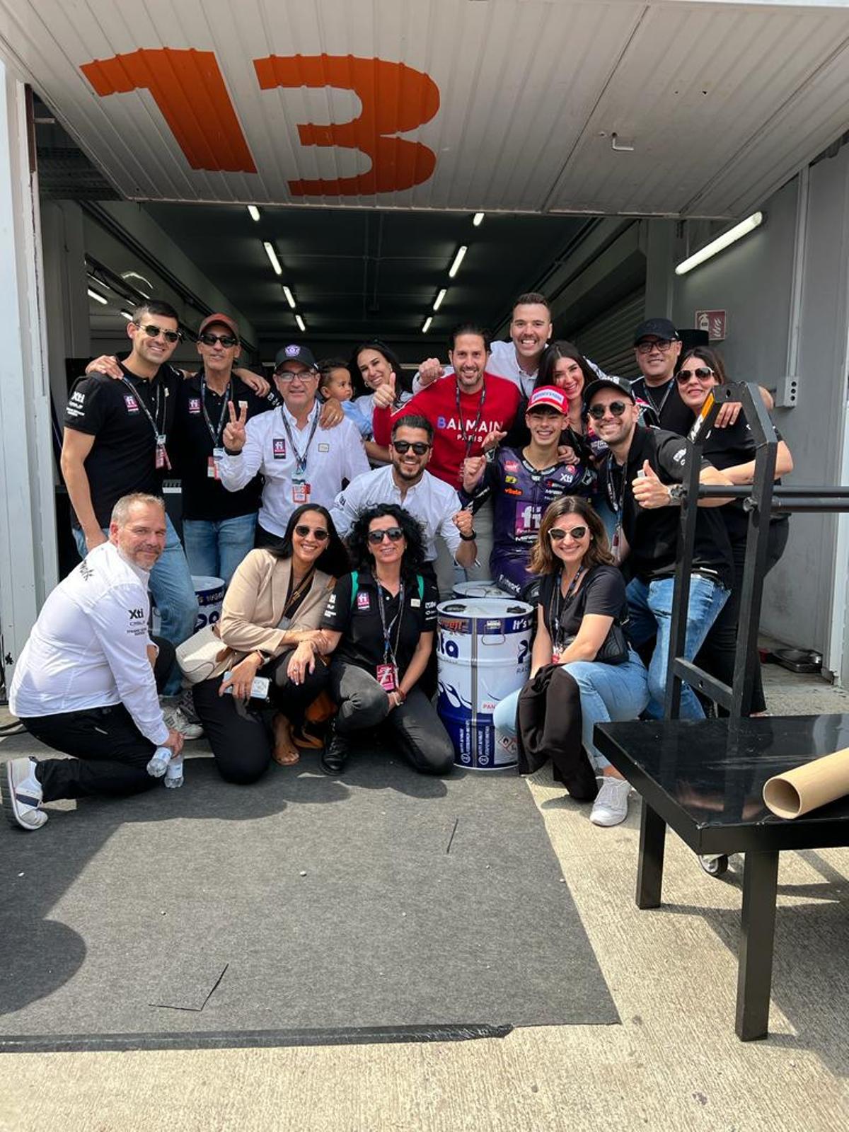 Algunos de los integrantes de la escudería posan en el box del equipo tras la carrera en València.