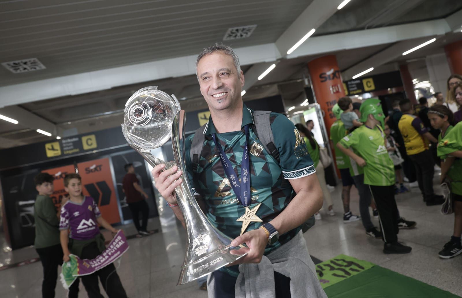 Medio centenar de aficionados reciben al Palma Futsal a su llegada a la isla tras conquistar la Champions