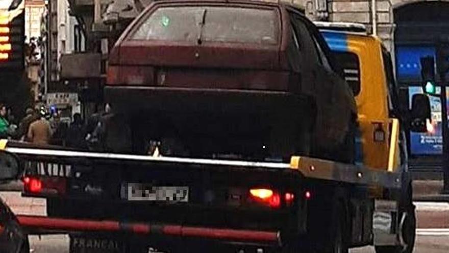 La grúa llevándose el coche del parking este martes.