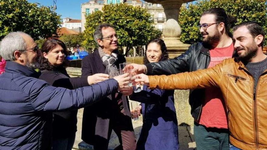 Los seis representantes brindan con agua ante la fuente de A Ferrería. // Faro