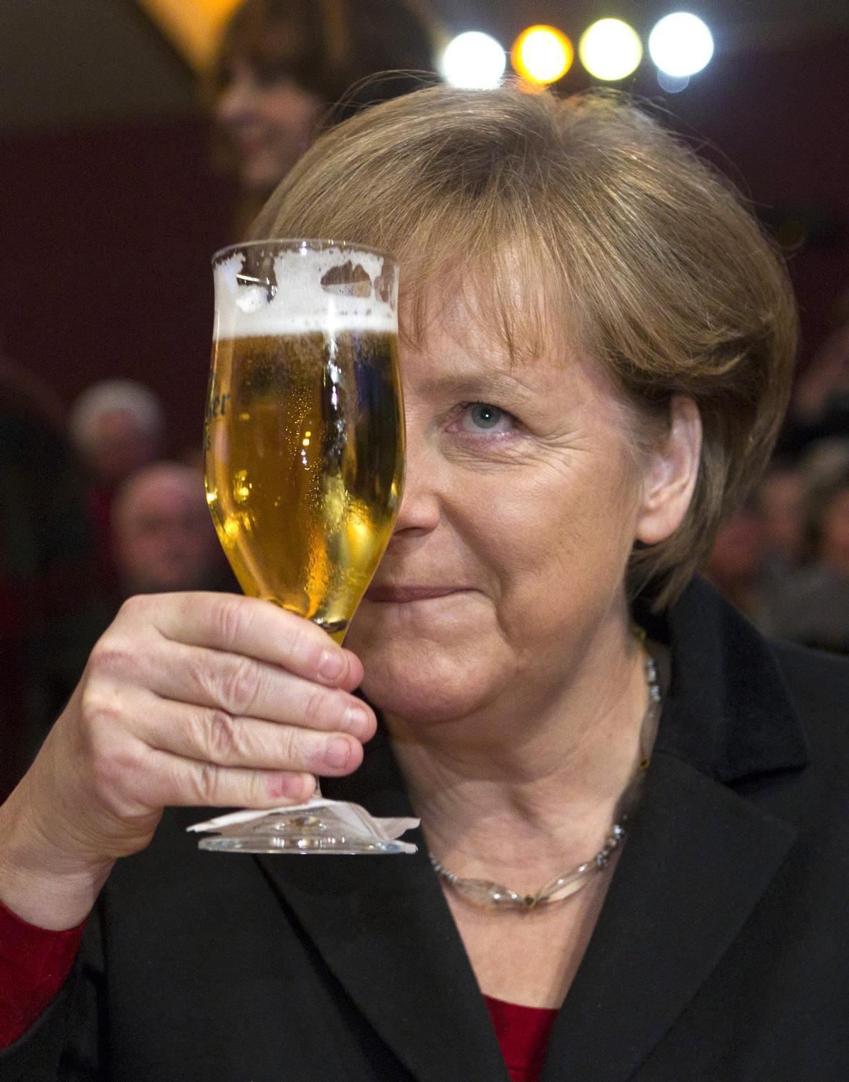 Angela Merkel bromea cerveza en mano durante un encuentro del CDU en Demmin, en febrero del 2012.