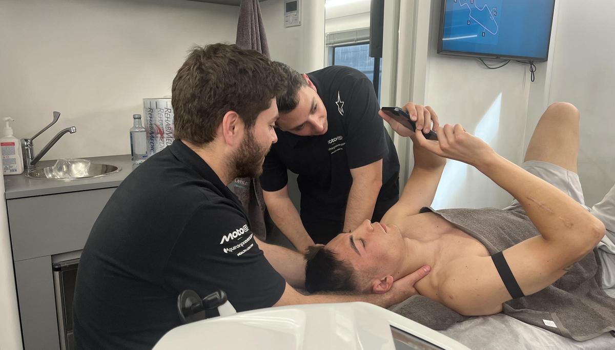 Raúl Fernández, piloto de MotoGP, les enseña a sus fisios un video de una derrapada suya.
