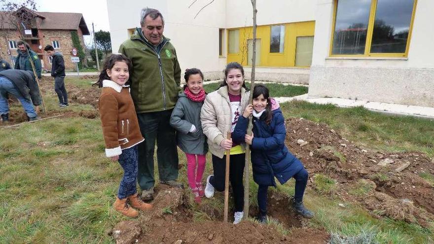 Escolares de San Vitero junto un agente medioambiental plantando un árbol.