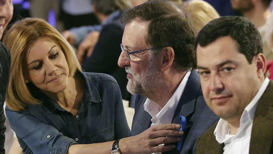 De Cospedal observa el lazo azul que luce Rajoy en su americana de concienciación del autismo, acompañado por el presidente del PP de Andalucía, Juanma Moreno, ayer, en Sevilla. // José Manuel Vidal