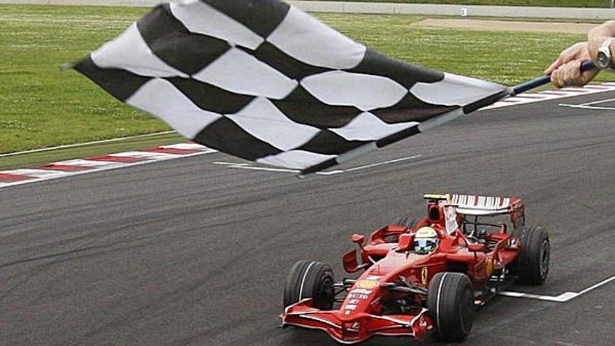 La bandera a cuadros da la bienvenida a Felipe Massa al cruzar la línea de meta. /