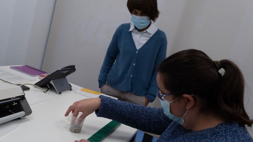 Rosa Sánchez aprende a identificar las letras en braille bajo la atenta mirada de su profesora, Asun Hernández.