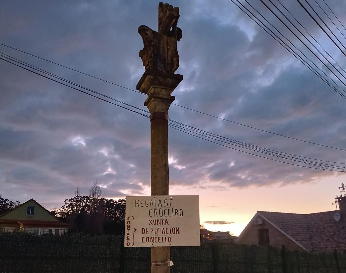El cruceiro de A Roza, en Beluso, con el nuevo cartel de protesta colocado por los vecinos.