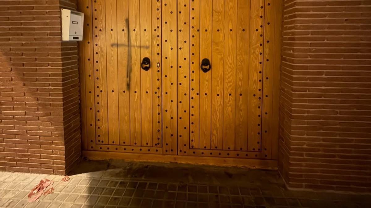 La porta de la mesquita amb la creu pintada i la carn de porc al terra