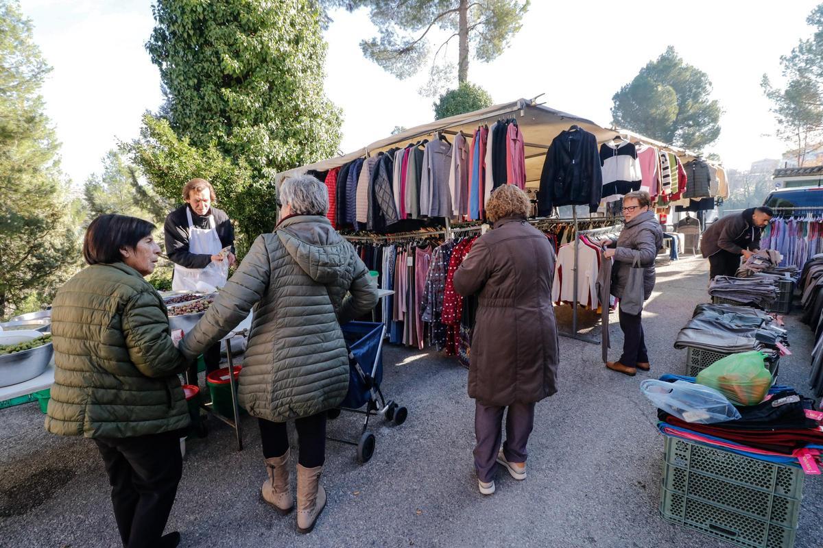 Puestos de ropa en el mercadillo que se instala en Planes los jueves, junto a  otro de frutos secos.