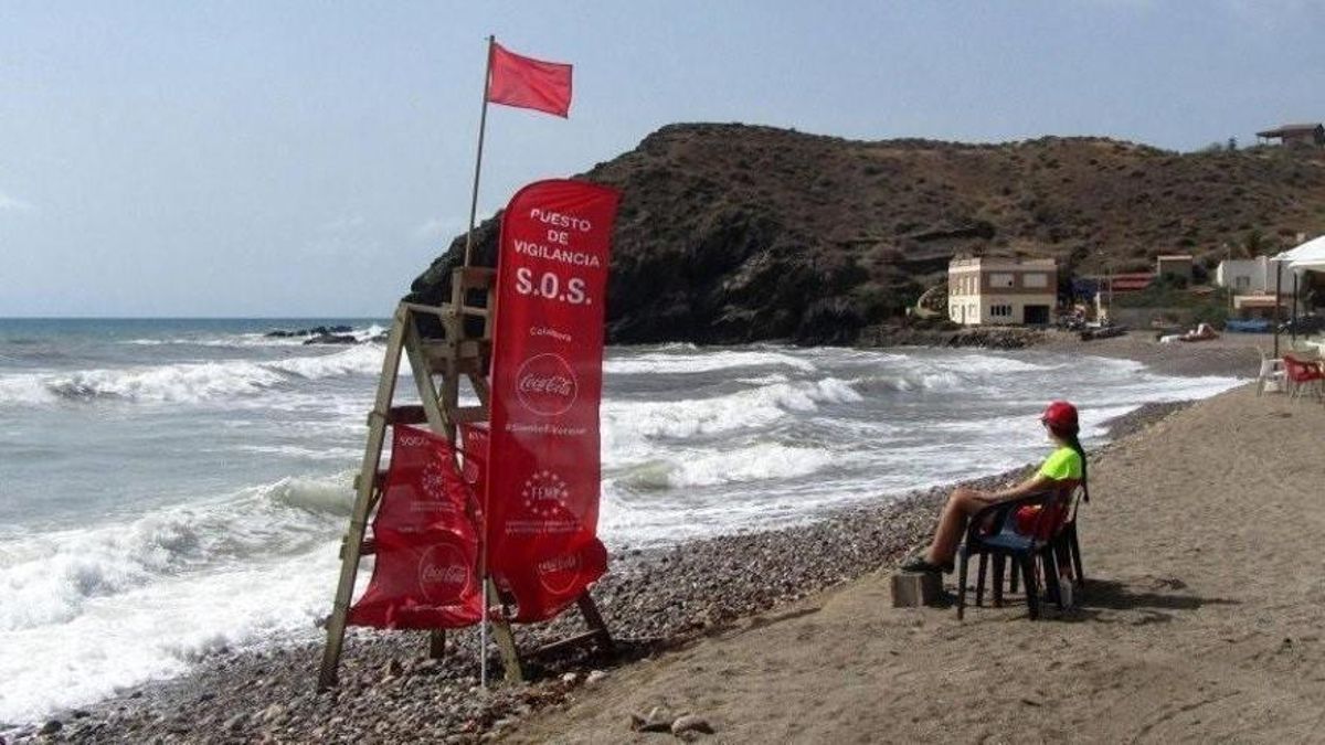 Un puesto de vigilancia en una playa con bandera roja.