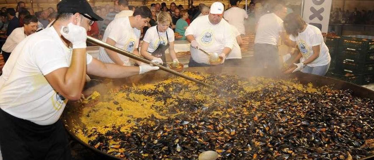 Miembros de la comisión preparando la paella en la edición anterior. // Bernabé/Javier Lalín