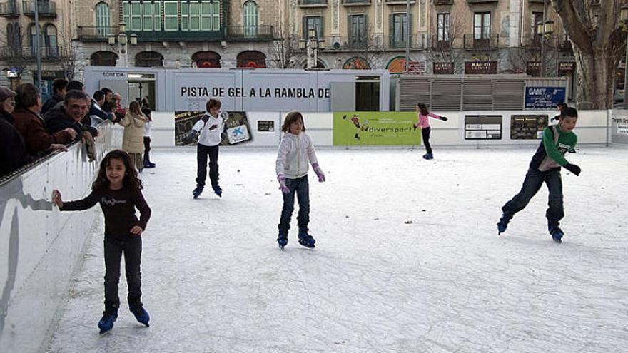 Gent patinant a la pista instal·lada a la Rambla de Figueres.