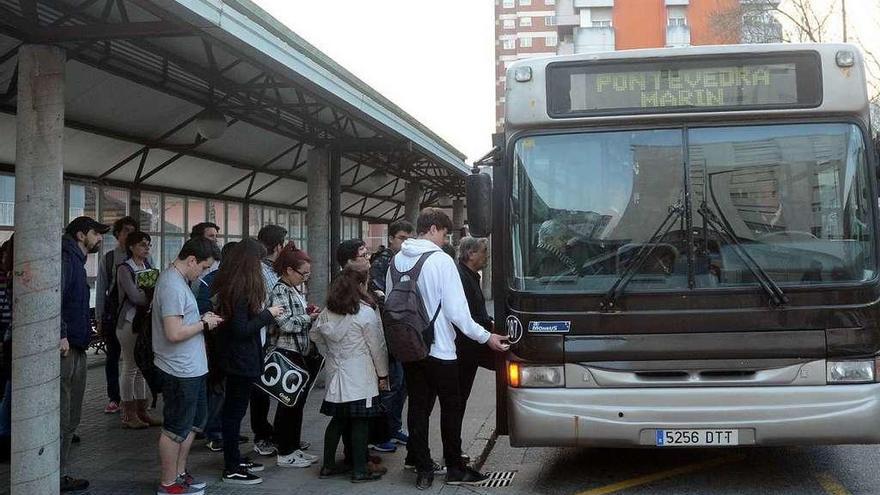Usuarios del transporte público suben al autobús en la parada de la plaza de Galicia. // R. Vázquez