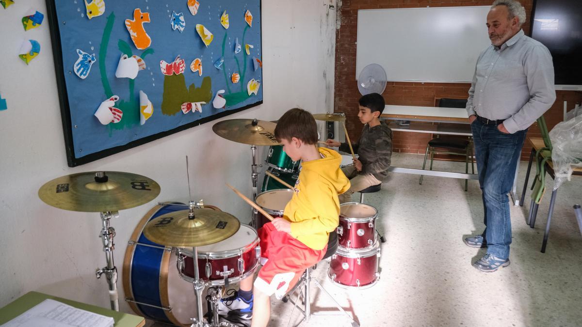 Dos alumnos del aula de percusión tocan la batería en la sede del colegio Juventud.